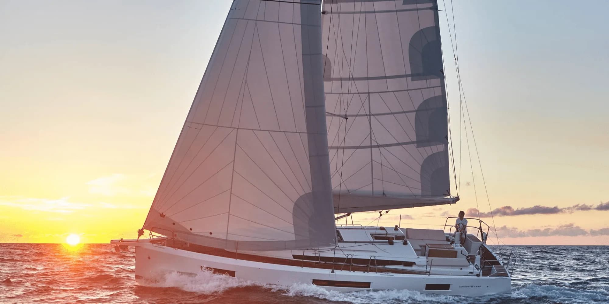 A sailing yacht under way at sunset
